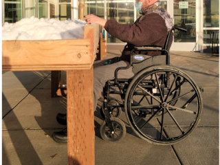 Accessible raised garden bed with man in wheelchair.