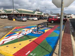 Artistic paint on asphalt and bike rack..