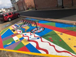 Artistic paint on asphalt and bike rack..