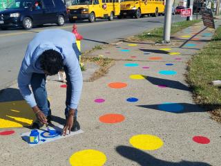 Painting polka dots on sidewalk