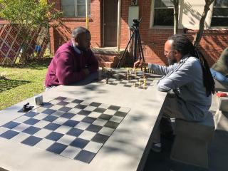 People playing chess outside on new game tables.