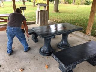 Outdoor chess table and benches under gazebo.