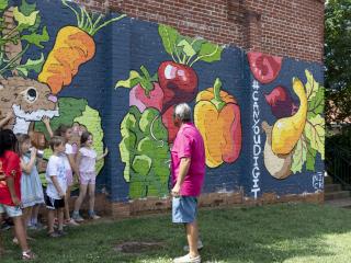 Children in front of vegetable mural.