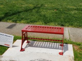 New red bench with Loop Project sign.
