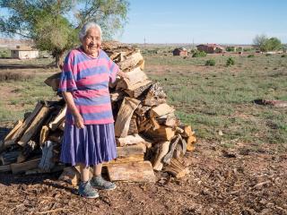 Native elder with new pile of firewood.