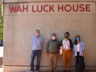 Four people in front of Wah Luck House.