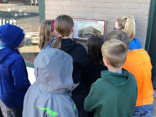 Group of children looking at plaque.
