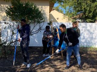 Volunteers raking community garden.
