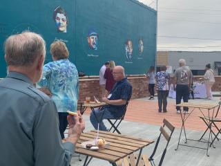 People sitting at tables in alley.