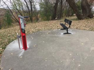 Bike repair station and bench along trail.