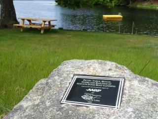 Rock with plaque acknowledging AARP for new bench, picnic table, steps and handrail.
