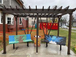 Two artistic benches under pergola.
