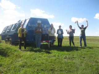 Group with new plastic recycling trailer holding recyclable items.