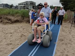 Accessible mats to access beach and beach wheelchair.