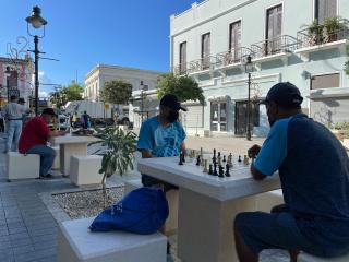 Two people playing chess on game table.