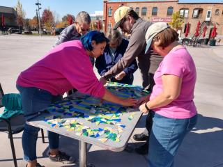 Group creating mosaic tile art.