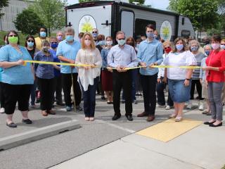 Ribbon cutting event in front of  mobile services trailer.