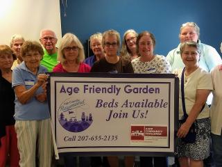 Group with age friendly garden sign.