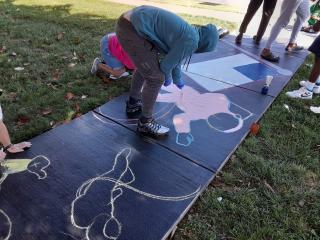 Painting sidewalk with space theme.