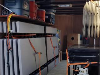 Inside of Trailer with tables, chairs, bbq grill, and games