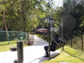 Linear park with swing bench and water fountain.