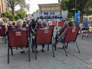 Red chairs reserved for older adults at outdoor event.