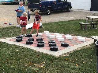 Children playing on large checkers board at community plaza