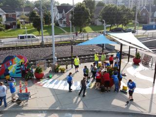 Overhead view of new sidewalk mural and shade structure at transit stop.