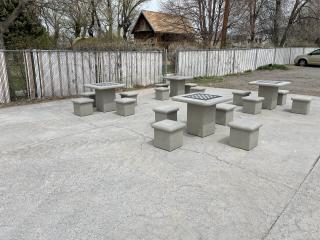 Four concrete checkers tables with seats.