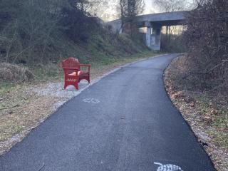 New bench and stencil on paved path.