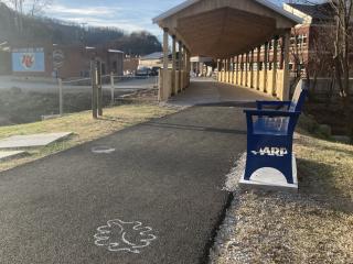 Covered bridge, new benchn and stencil on paved path.
