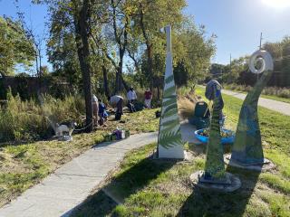 Volunteers planting around fern sculpture
