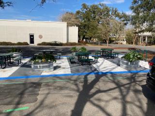 Parklet with tables, seating, and planters.