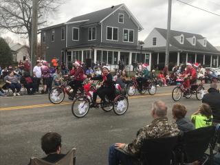 Riding four decorated tricycles in holiday parade.