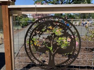 Artistic tree medallion sign at garden entrance.
