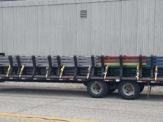 Flatbed truck returns with plastic benches.