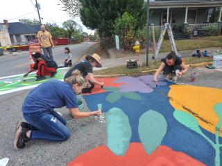 Volunteers painting crosswalk.