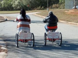 Two adults on trycycles.