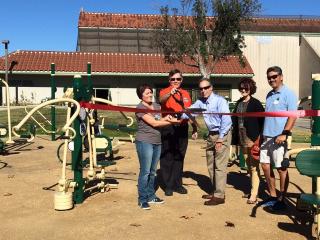 Ribbon cutting event for fitness equipment.