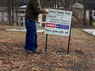 Installing sign about new pocket park.