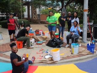 Volunteers painting street corner.