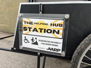 Sign for the The Helping Hub Station on the cart.