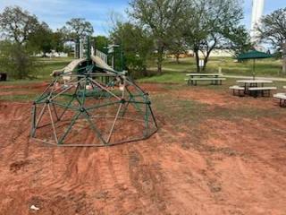 New playground equipment adjacent to picnic tables.