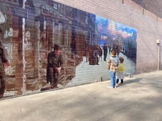 Two children look at mural