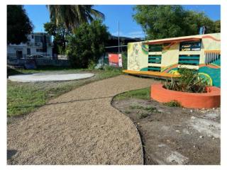 New plaza in front of museum with mural, seating, planters, and batey.