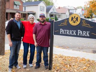 Adults standing with sign for Patrick Park.