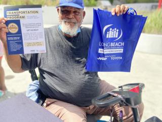 Man holding flyer promoting transportation.