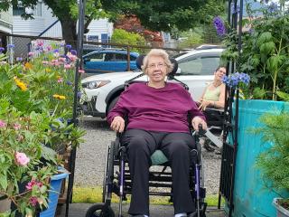 Woman in wheelchair entering garden.