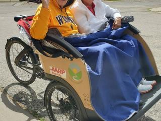 Two adults riding in trishaw .