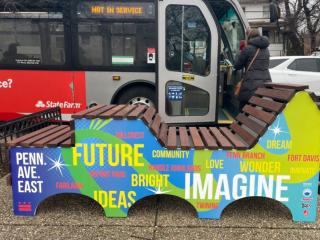 Imagination Bench with bus in background.